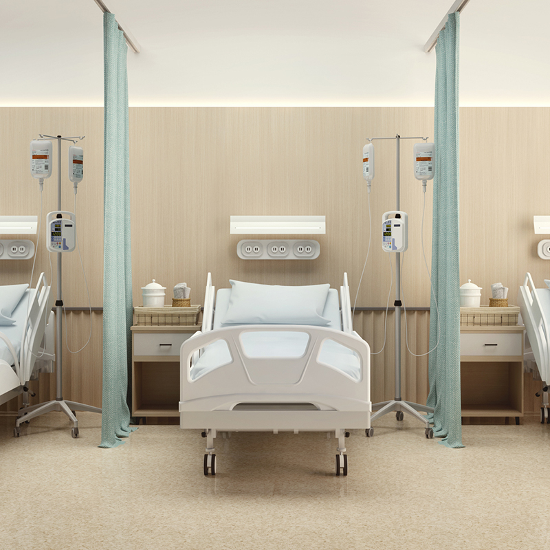 A hospital room with three symmetrical hospital beds and curtains separating them