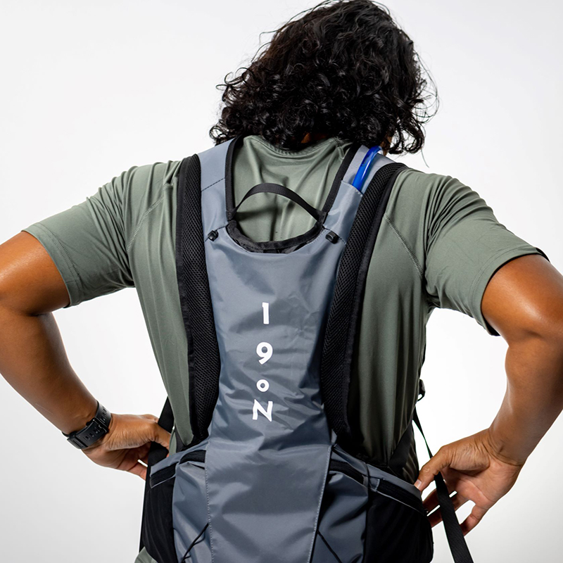 A man with his back turned to the camera wearing a Honu vest