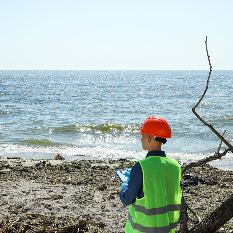 An engineer surveying the beach for coastal erosion