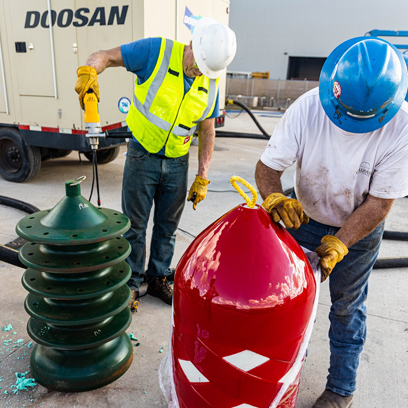Two workers unwrapping and using large machinery