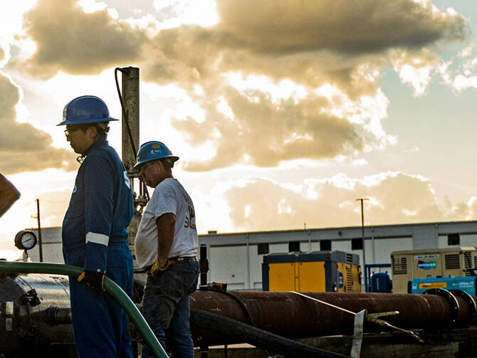 A group of workers examining a cable at a work site