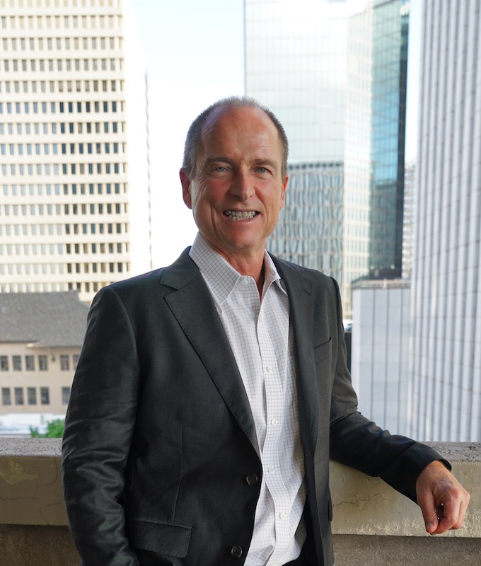 A photo of Pat Sullivan with the Honolulu skyline behind him