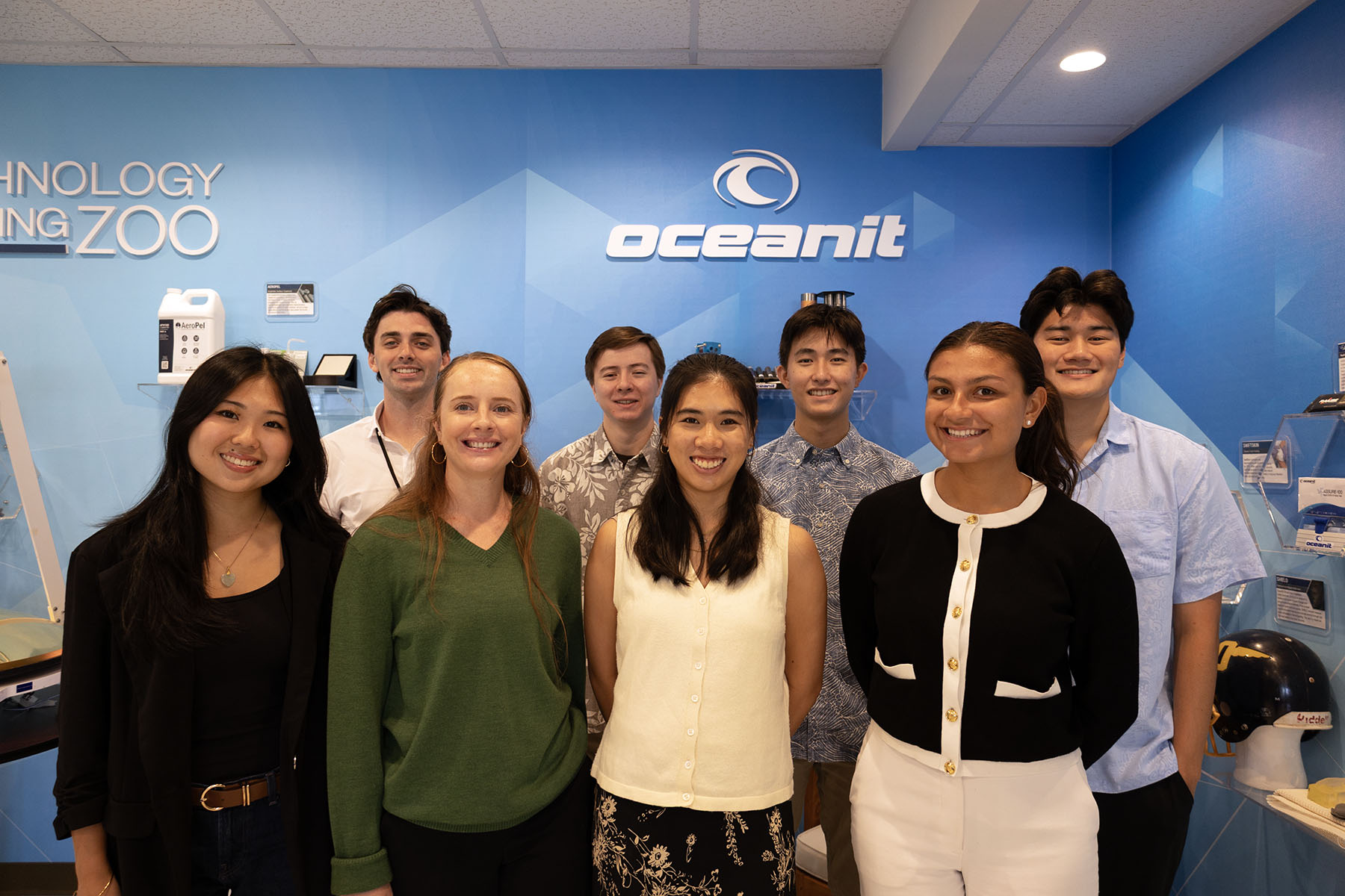 A group of eight interns stands in front of the Oceanit Petting Zoo